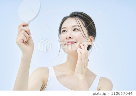 手鏡で肌の状態を確かめる女性 手鏡で肌の状態を確かめる女性 110657044