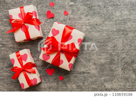 Top view photo of valentine day decorations gift box with red ribbon bow on colored background. Holiday gift boxes with top view 110659186