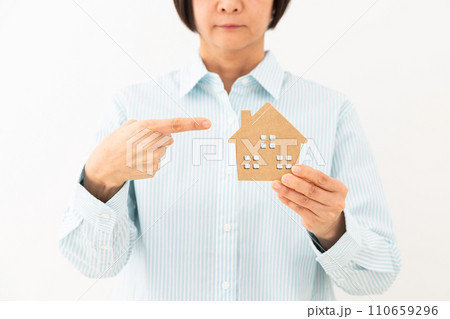 マンションの住宅模型を指差すミドル女性 110659296