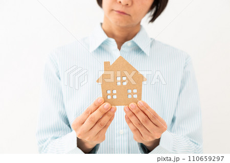 戸建ての住宅模型を持って悩むミドル女性 110659297
