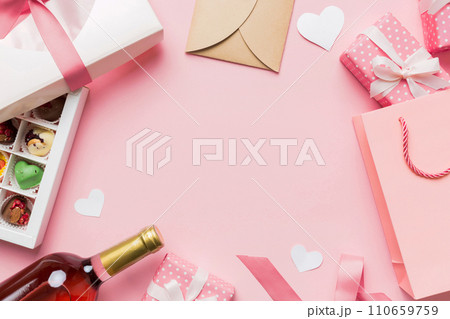 top view photo of st valentine day decor shopping, bag, wine, bottle, envelope, gift, box, candy and red heart on colored background with empty space. Frame background top view photo of st valentine day decor shopping, bag, wine, bottle, envelope, gift, box, candy and red heart on colored background with empty space. Frame background 110659759