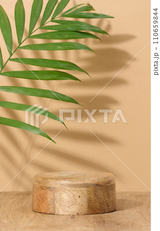 Round brown wooden stand on a beige background, a place to display cosmetics and products 110659844
