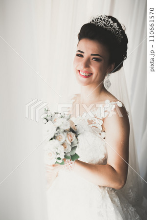 Portrait of stunning bride with long hair posing with great bouquet 110661570