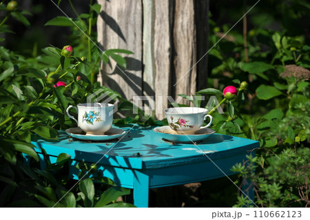 White China Teacups on Blue Table in Garden Double as Garden Art and Bird Baths 110662123