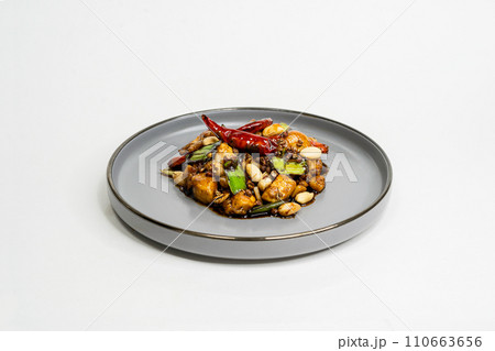 fried assorted vegetables with meat in a flat plate on a white background, side view 110663656