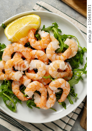 Cooked shrimps in a plate with lemon, seafood, bright background.  110663831