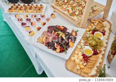 light snacks for the holiday, catering. Various light snacks. Catering plate. Assortment of sandwiches on the buffet table. meat, fish, vegetable canapes. 110663989
