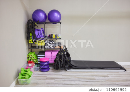 Unrolled yoga mat on wooden floor in modern fitness center or at home with big windows and white brick walls, comfortable space for doing sport exercises, meditating, yoga equipment 110663992