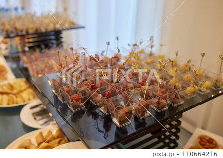 light snacks for the holiday, catering. Various light snacks. Catering plate. Assortment of sandwiches on the buffet table. meat, fish, vegetable canapes. 110664216