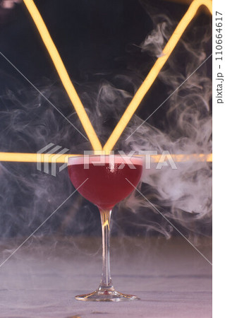 Summer cocktail with fruit and ice. Drink on white table over pink wall in sunlight with palm leaf shadow. Summer, tropical, fresh cocktail concept. 110664617