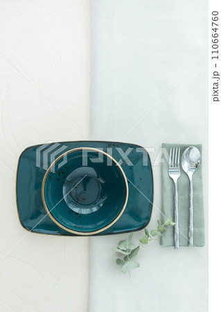 Above view of empty soup bowl with rectangular dish with cutlery on table 110664760