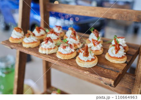 light snacks for the holiday, catering. Various light snacks. Catering plate. Assortment of sandwiches on the buffet table. meat, fish, vegetable canapes. 110664963