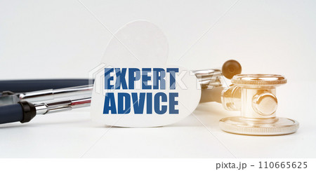 On the white surface there is a stethoscope and a heart plate with the inscription - EXPERT ADVICE 110665625
