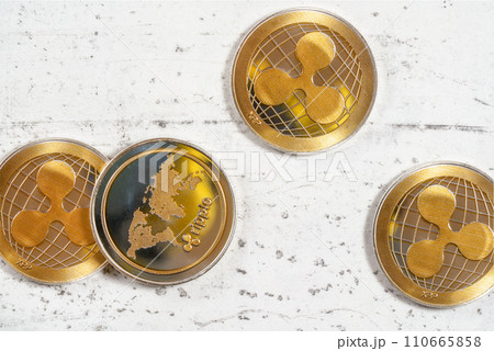 Top down view, golden XRP ripple cryptocurrency coins on white stone board 110665858