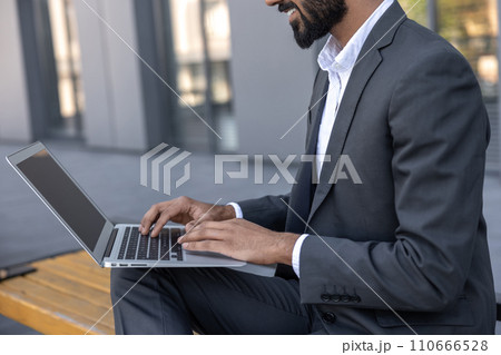 Close up of a businessman working on laptop 110666528