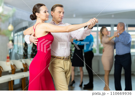 Woman learning to dance Vienneze waltz with man in dancing class 110669936