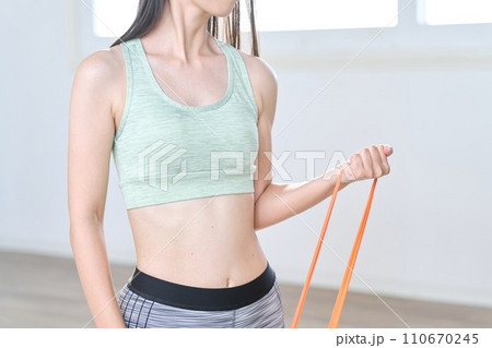 レジスタンスバンドを使って腕のトレーニングをする女性 110670245