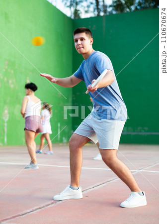 Concentrated young man paleta fronton player hitting ball with racket 110670674