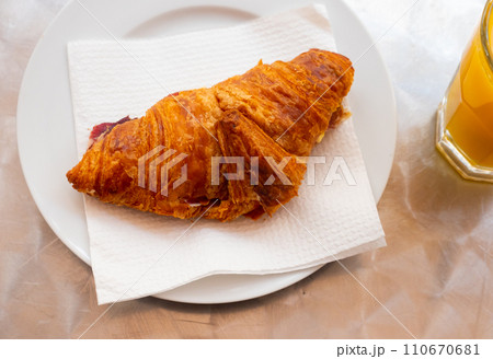 Art served appetizer on plate - delicate puff pastry croissant with thin slices of ham in middle 110670681