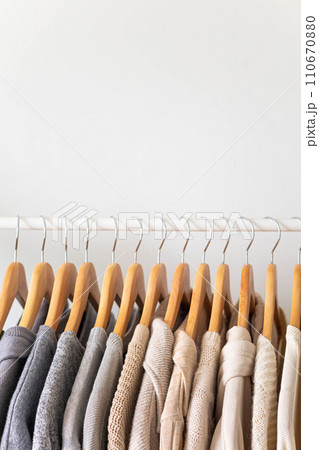 Hanger with beautiful neutral beige, white and gray clothes on a white background. Copy space. Hanger with beautiful neutral beige, white and gray clothes on a white background. Copy space. 110670880
