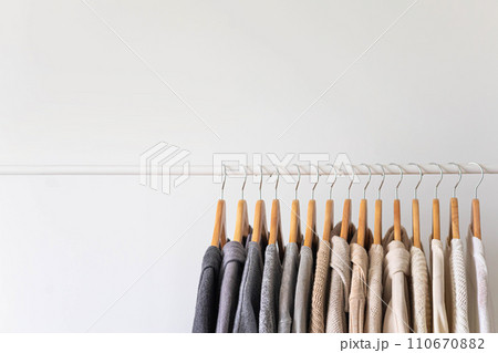 Hanger with neutral beige and white clothes on a white background. Hanger with neutral beige and white clothes on a white background. 110670882