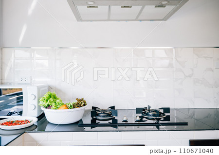 Luxury house kitchen with a gas stove by the sink cabinets. Modern design clean furniture steel appliances. Comfortable cooking area empty table perfect for a bright living space give me. Luxury house kitchen with a gas stove by the sink cabinets. Modern design clean furniture steel appliances. Comfortable cooking area empty table perfect for a bright living space give me. 110671040