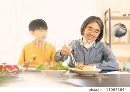 笑顔で食事をする父親と息子 110671644