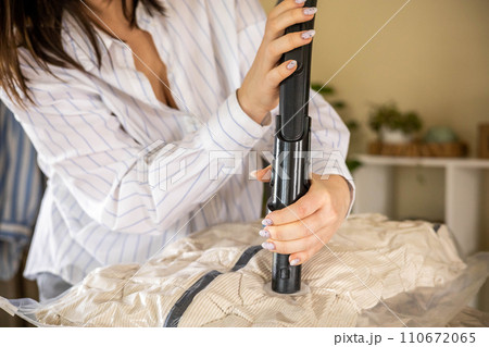 Woman prepare outerwear for seasonal storage with easy vacuum package technology compressed process Woman prepare outerwear for seasonal storage with easy vacuum package technology compressed process 110672065