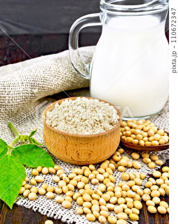 Flour soy in bowl with soybeans and milk on dark board 110672347