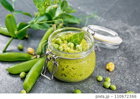 Hummus from green peas in jar on granite table Hummus from green peas in jar on granite table 110672366