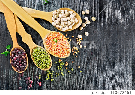 Lentils with chickpeas and beans in spoons on dark board top Lentils with chickpeas and beans in spoons on dark board top 110672461
