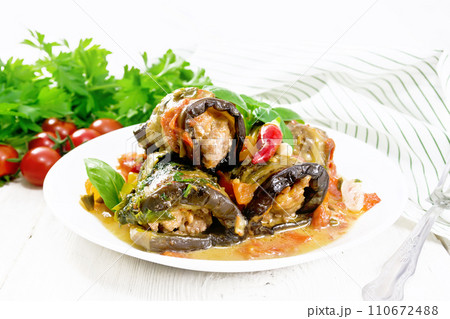 Rolls of eggplant with mincemeat in plate on table Rolls of eggplant with mincemeat in plate on table 110672488