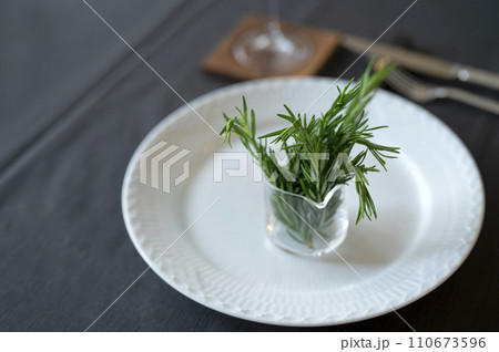 テーブルの上の白い皿とローズマリー 110673596