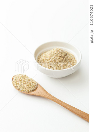 器に入ったすりゴマと木製スプーン　白バック 110674023