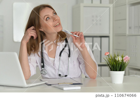 Beautiful girl doctor working at her laptop Beautiful girl doctor working at her laptop 110674066