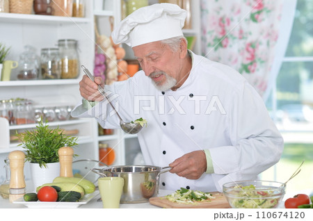 Portrait of chef preparing dinner at kitchen Portrait of chef preparing dinner at kitchen 110674120