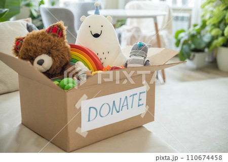 On the living room couch is a box full of toys for donation. Teddy bear soft toy On the living room couch is a box full of toys for donation. Teddy bear soft toy 110674458