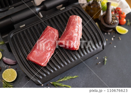 Two pieces of fresh tuna fillet on a electric grill Two pieces of fresh tuna fillet on a electric grill 110676623