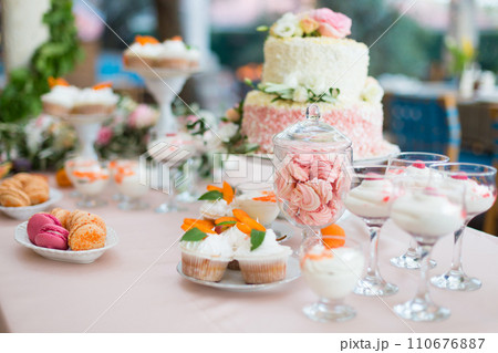 Dessert table for a party. Cake, cupcakes, sweetness and flowers 110676887