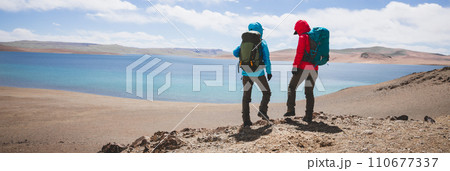 Two women backpackers hiking in beautiful winter high altitude mountains Two women backpackers hiking in beautiful winter high altitude mountains 110677337