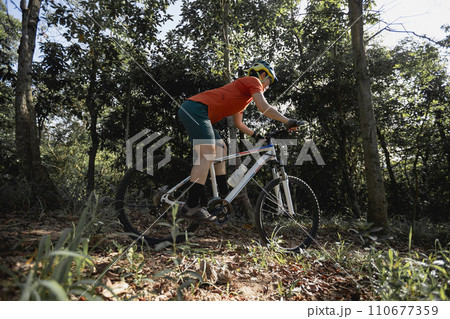 Mountain biking on spring forest trail Mountain biking on spring forest trail 110677359