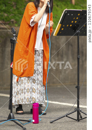 野外イベントで歌う女性 110679343