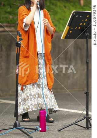 野外イベントで歌う女性 110679346