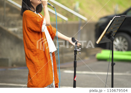 野外イベントで歌う女性 110679504