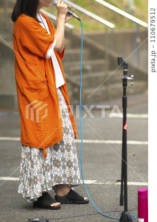 野外イベントで歌う女性 110679512