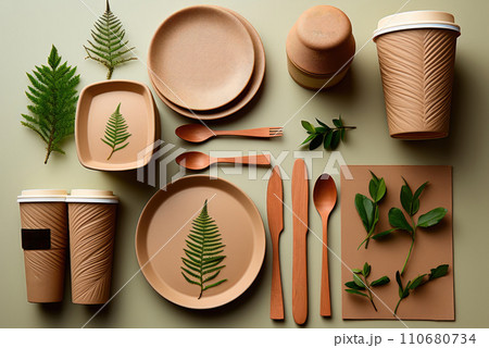 Natural eco-friendly disposable tableware, fork, spoon, plate, glasses made of paper and wood on a green background. Zero waste and ecology 110680734