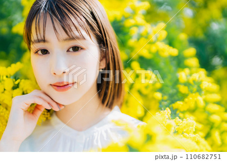 ミモザに囲まれる若い女性 110682751