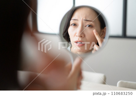 鏡を見て肌の調子が気になる女性 110683250