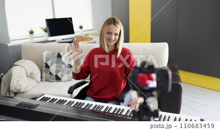 Disabled woman in wheelchair play piano on camera, talented pianist present her art for social media 110683459
