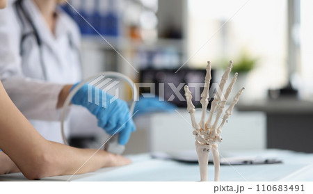 Doctor do ultrasound of hand, skeleton hand model on desk, medical anatomy science Doctor do ultrasound of hand, skeleton hand model on desk, medical anatomy science 110683491